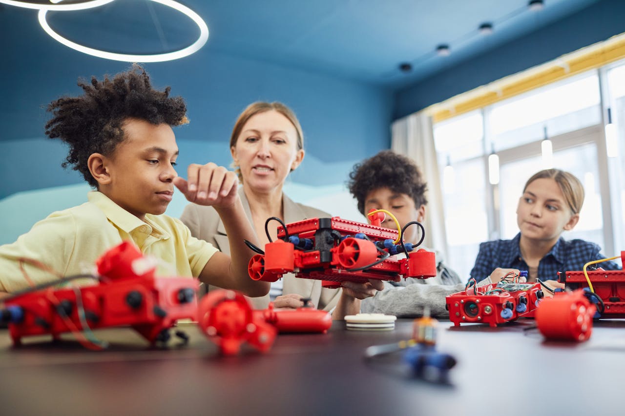 Young students and teacher collaborating on a robotics project in a classroom setting.